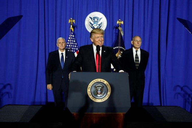 U.S. President Donald Trump (C), flanked by Vice President Mike Pence (L) and Homeland Security Secretary John Kelly (R), takes the stage to deliver remarks at Homeland Security headquarters in Washington, U.S. January 25, 2017. REUTERS/Jonathan Ernst